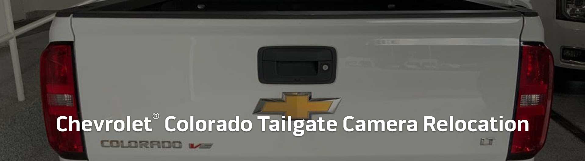 An image showing the tailgate handle of a Chevrolet Colorado with a built-in backup camera.