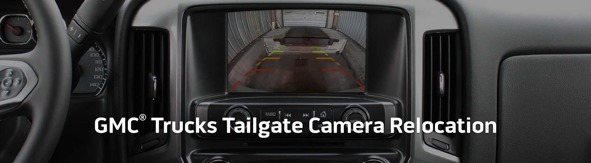 An image showing the in-dash monitor of a GMC truck. The in-dash monitor shows that the truck is in reverse and is displaying both the backup camera and video from the cameras on the front and side of the truck. The image has text that reads GMC Trucks Tailgate Camera Relocation.