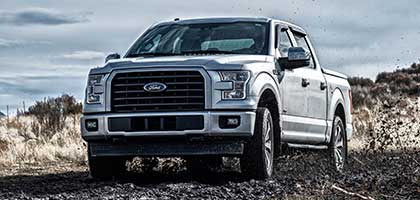 An image showing a silver Ford F-150 parked in an off-road setting.