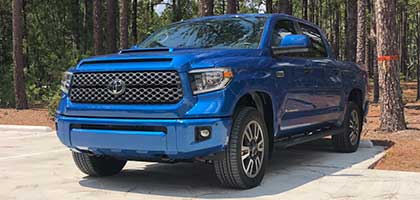 An image showing a blue Toyota Tundra truck in a parking lot.
