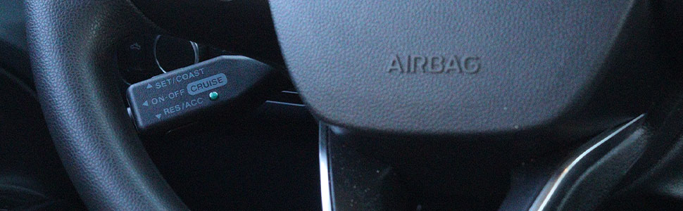 Image showing the steering wheel of a 2022 Ford Maverick XL. Through the spoke of the steering wheel the Rostra cruise control switch can be seen.