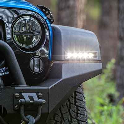 The fender of a Jeep Wrangler with Rostra LED DRLs installed and illuminated.
