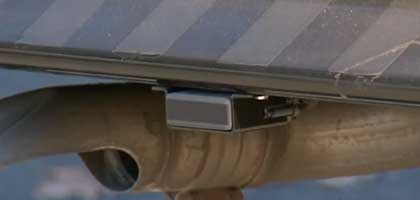 An image showing the underside of a school bus. In the image a sensor can be seen attached to the bus.