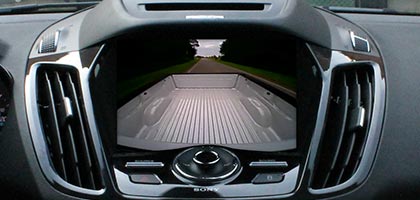 An image showing the dashboard of a vehicle. On-screen is video from a secondary cameras that has been added to the vehicle.